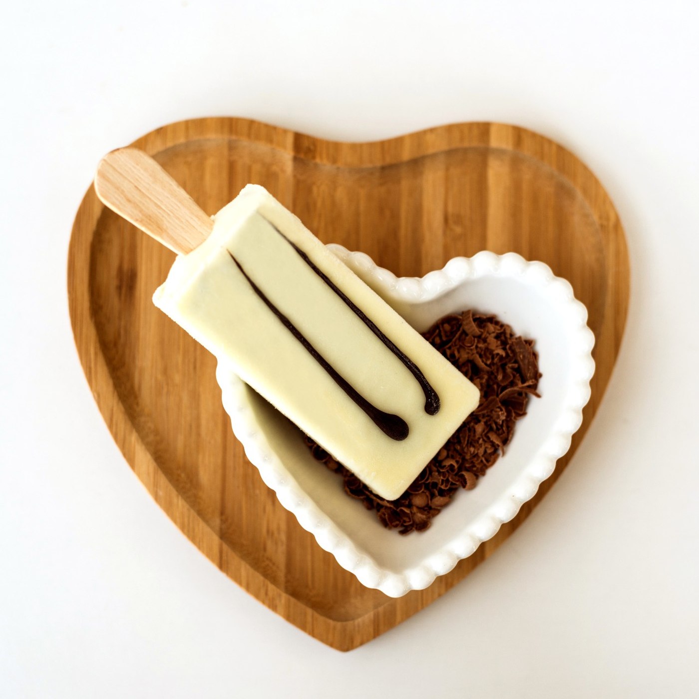 Picolé Bliss de chocolate branco servido em prato de coração com raspas de chocolate